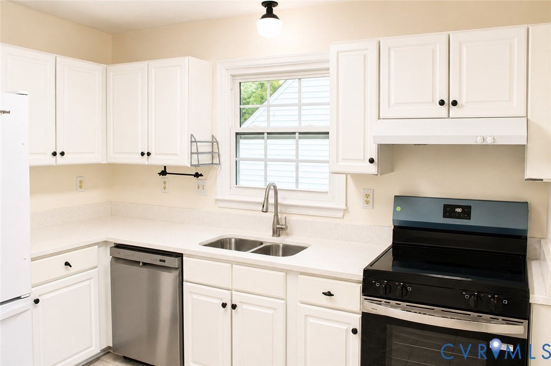 2120 Oakhampton Place, Henrico, VA 23233 Kitchen featuring white cabinetry with dark hardware, a stainless steel double basin sink with a gooseneck faucet, light-toned countertops, a stainless steel dishwasher, and a black range with a stainless steel handle