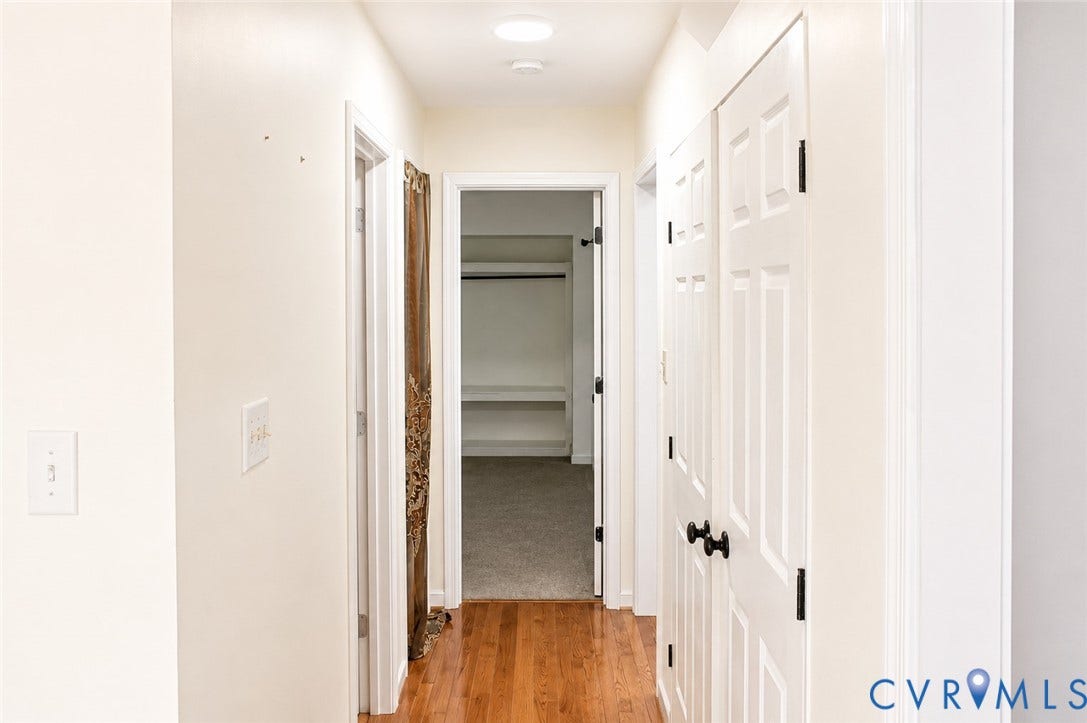 2120 Oakhampton Place, Henrico, VA 23233 Hardwood flooring extending through a hallway with white paneled doors and recessed lighting