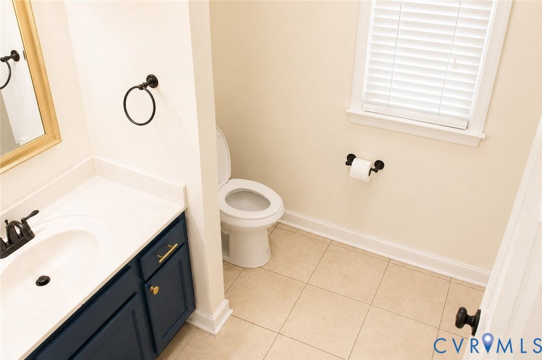 2120 Oakhampton Place, Henrico, VA 23233 Bathroom vanity featuring a white countertop with integrated sink, dark blue cabinetry, and gold-tone hardware