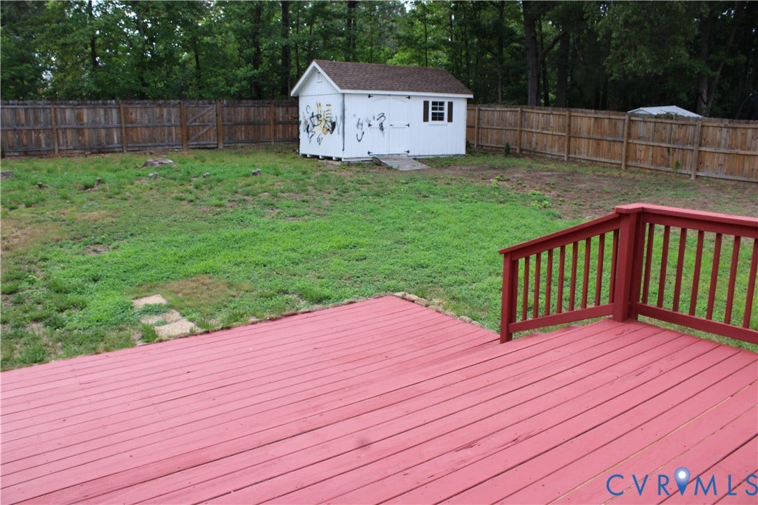 2120 Oakhampton Place, Henrico, VA 23233 Spacious backyard with a red-stained deck featuring railings