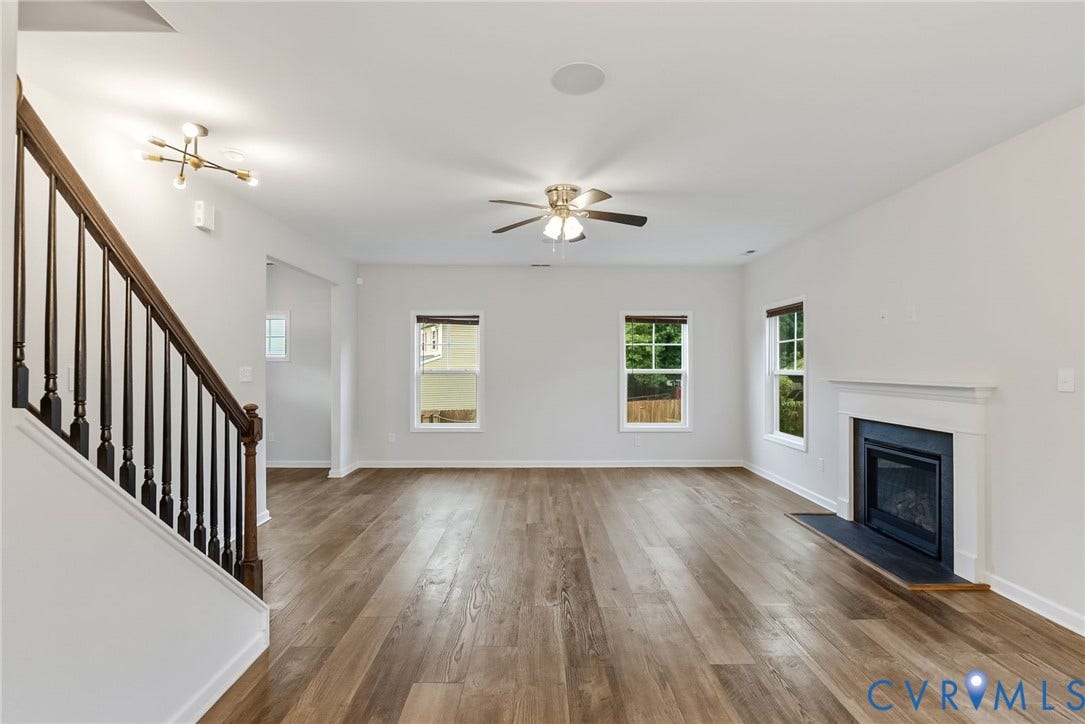 2007 Arcadia Avenue, Chester, VA 23831 Spacious interior featuring wood-finish flooring, a white mantel fireplace with a dark hearth, and multiple windows