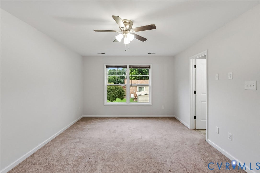 2007 Arcadia Avenue, Chester, VA 23831 Neutral-toned carpeting paired with white walls, a multi-pane window, and a ceiling fan with integrated lighting