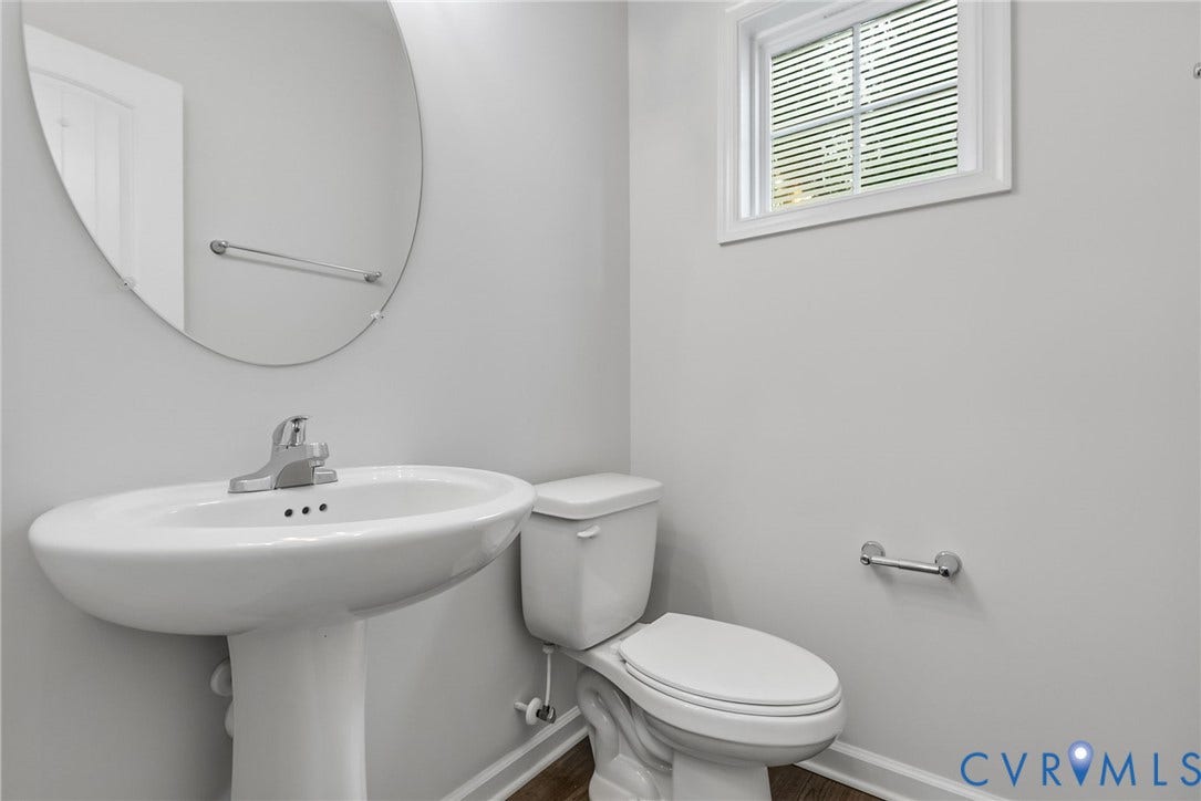 2007 Arcadia Avenue, Chester, VA 23831 Bathroom featuring a pedestal sink, oval mirror, white toilet, and wood-finish flooring
