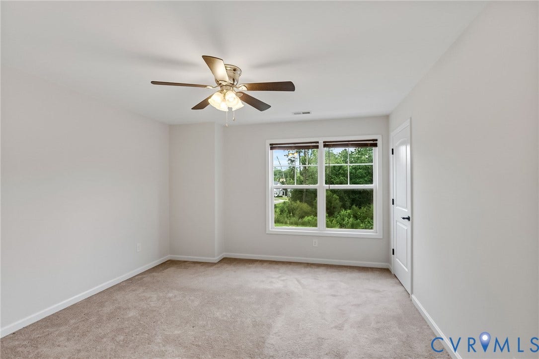 2007 Arcadia Avenue, Chester, VA 23831 Bright interior space featuring a multi-pane window, neutral carpet flooring, a ceiling fan with integrated lighting, and a white interior door with black hardware