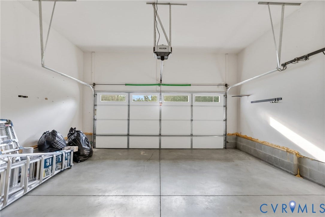 2007 Arcadia Avenue, Chester, VA 23831 Spacious garage featuring a concrete floor, white walls, and an overhead garage door with integrated windows