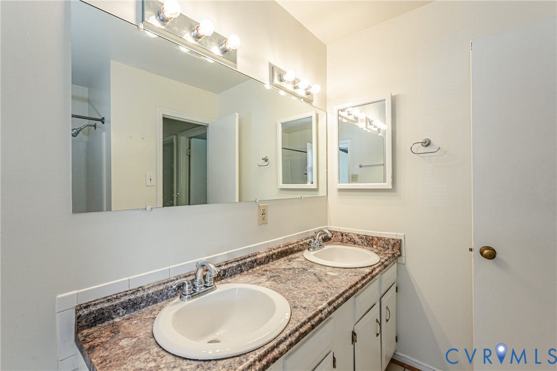 Dual undermount sinks set within a granite-look countertop with an integrated backsplash