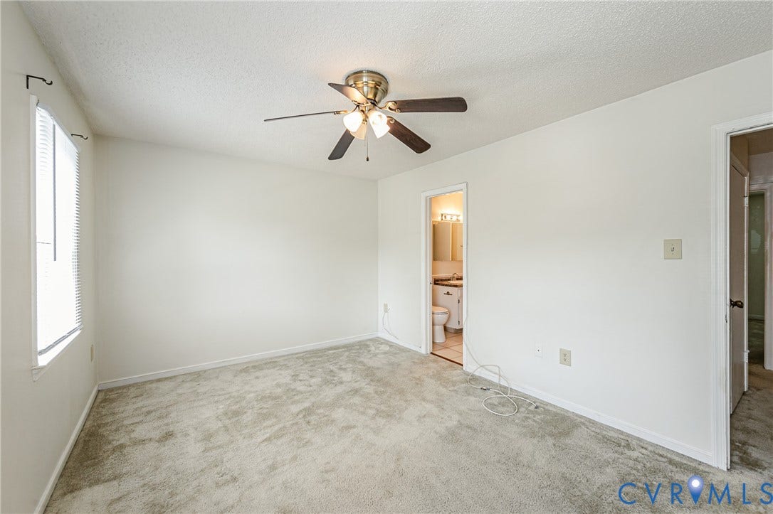 Spacious room featuring neutral carpeting, a ceiling fan with integrated lighting, and a single window with blinds