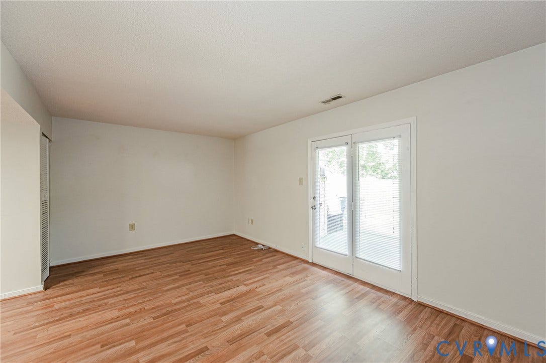 Spacious interior featuring wood-finish flooring, white walls, and bright white trim