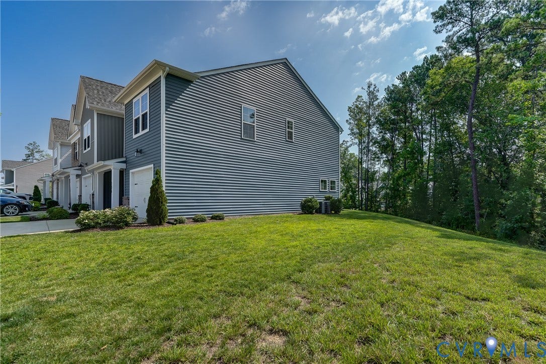 End-unit townhome featuring horizontal siding, white trim accents, and a single-car garage