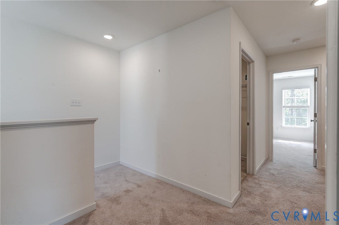 Upper-level hallway with neutral carpeting
