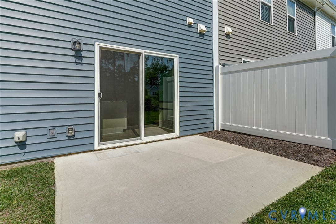 Concrete patio with a sliding glass door entry