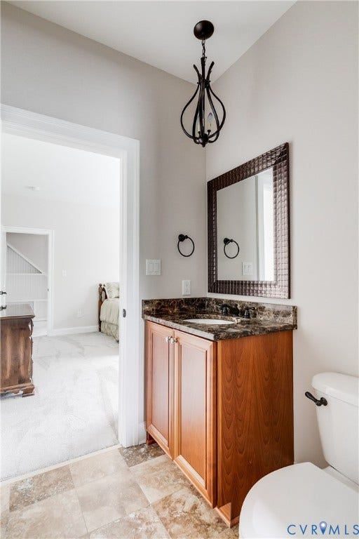 1978 Farnborough Drive, Midlothian, VA 23112 Powder room featuring a wood-finish vanity with a stone countertop and an integrated sink, a framed wall mirror, and a decorative pendant light fixture