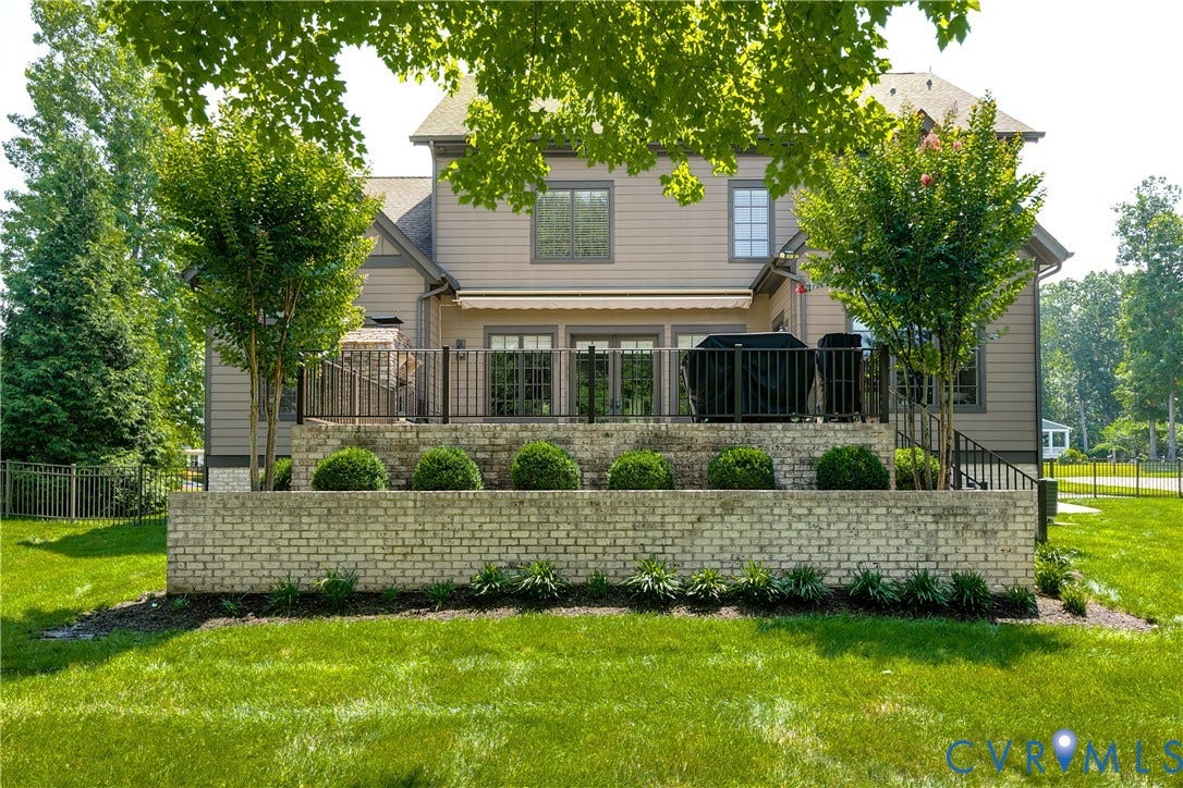 1978 Farnborough Drive, Midlothian, VA 23112 Rear exterior with a raised deck, light brick retaining wall, and mature landscaping