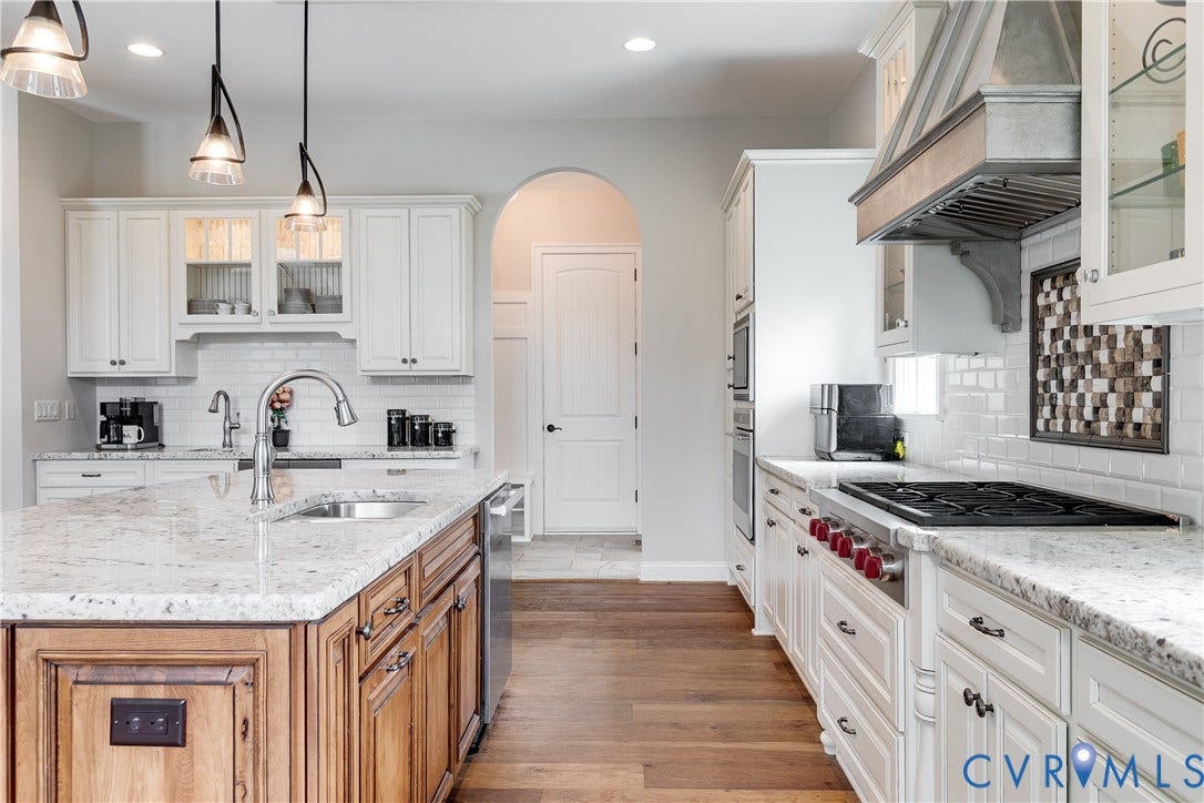 1978 Farnborough Drive, Midlothian, VA 23112 Gourmet kitchen featuring a central island with a stainless steel sink, granite countertops, white subway tile backsplash, built-in double ovens, and a professional-grade range with a custom hood
