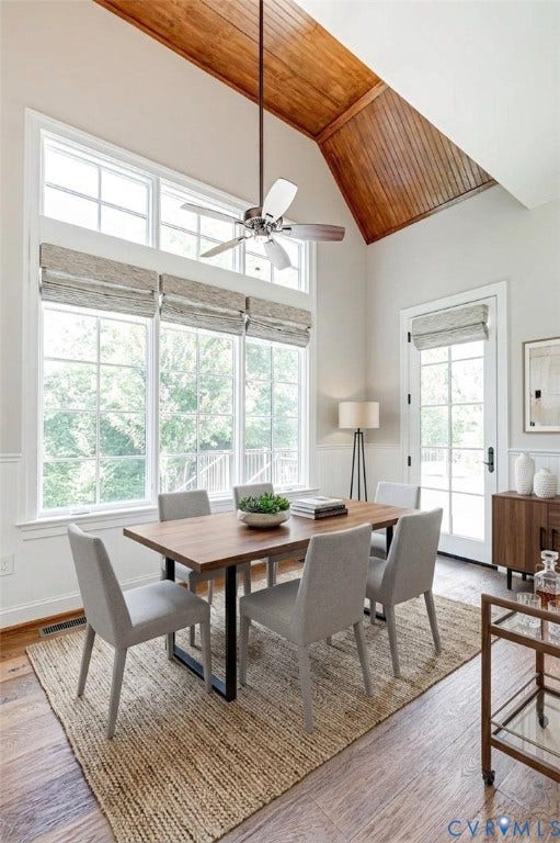 1978 Farnborough Drive, Midlothian, VA 23112 Hardwood flooring extending throughout an open-concept interior featuring a dining area with a coffered ceiling and orb chandelier, and a living area with exposed beam ceiling and multiple glass-paned doors. Virtually Staged