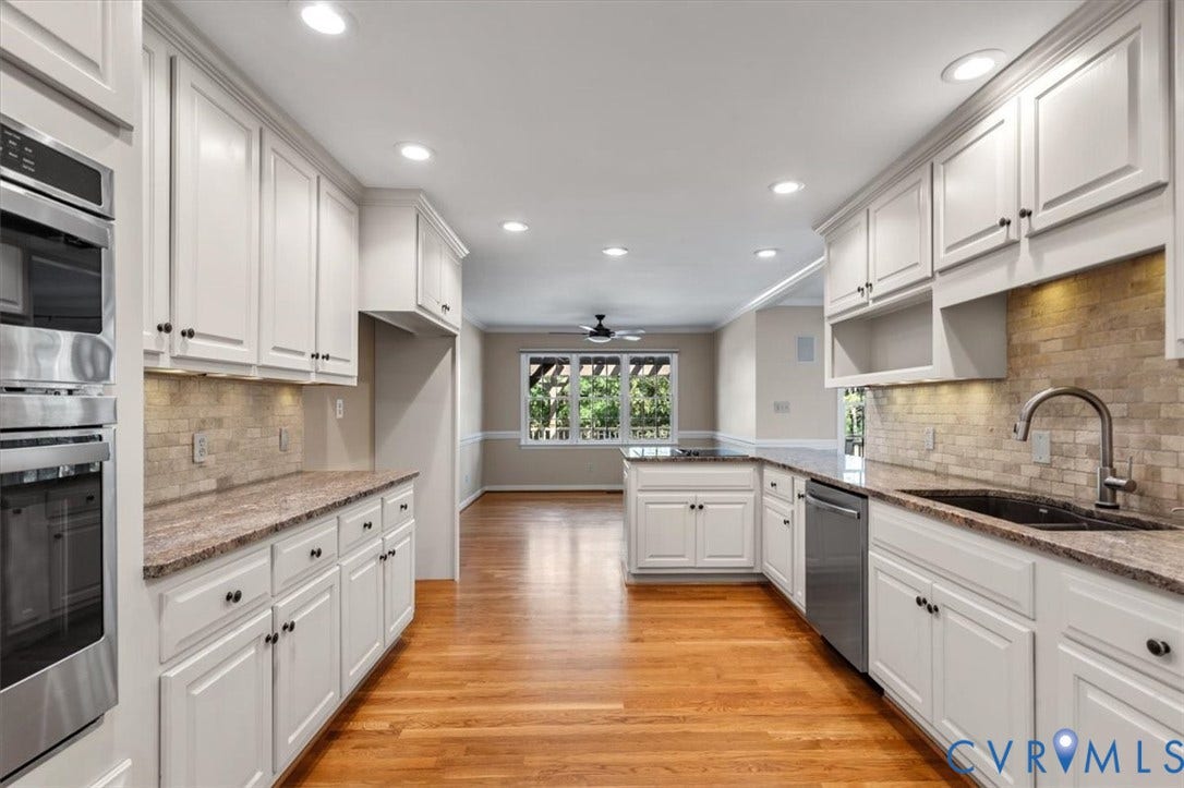 1437 Palmore Road, Powhatan, VA 23139 Bright kitchen featuring white shaker cabinetry, granite countertops, stainless steel appliances including double wall ovens and a dishwasher, and wood-finish flooring