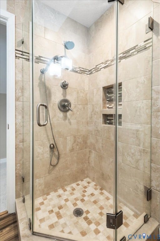 1437 Palmore Road, Powhatan, VA 23139 Glass-enclosed shower featuring natural-toned tile walls and a mosaic tile floor