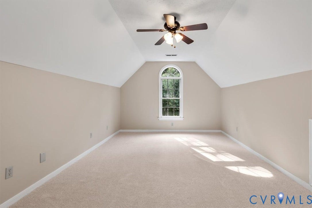 1437 Palmore Road, Powhatan, VA 23139 Spacious room featuring neutral carpeting, a vaulted ceiling, and an arched window