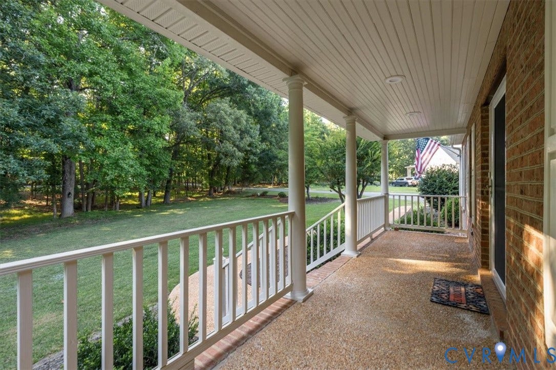1437 Palmore Road, Powhatan, VA 23139 Expansive covered front porch featuring a textured aggregate surface, white columns, and a white railing system