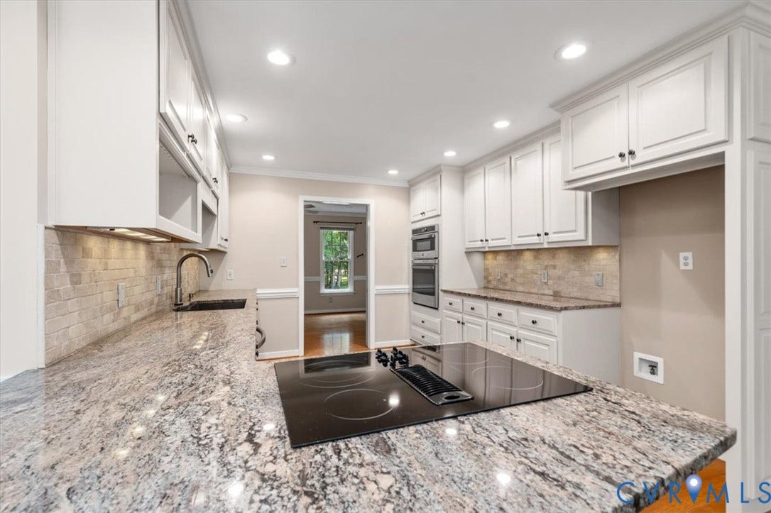 1437 Palmore Road, Powhatan, VA 23139 Modern kitchen featuring light-toned cabinetry, speckled countertops, and a tile backsplash