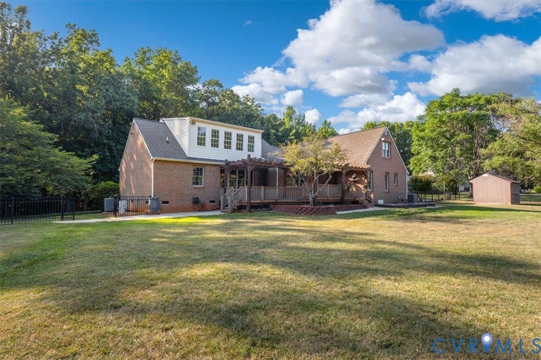 1437 Palmore Road, Powhatan, VA 23139 Expansive lawn bordering a brick house with a multi-level deck featuring a pergola