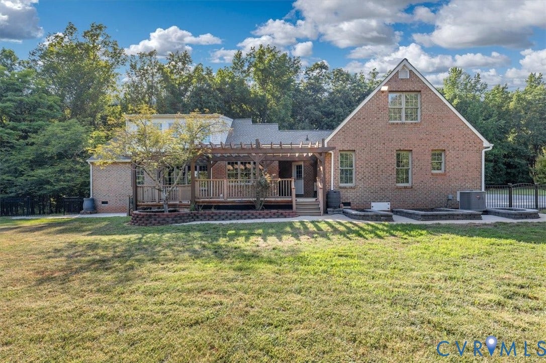 1437 Palmore Road, Powhatan, VA 23139 Rear exterior featuring a brick facade, multi-level wood-finish deck with a pergola, and a private fenced area