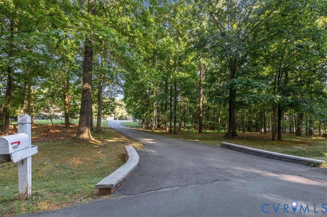 1437 Palmore Road, Powhatan, VA 23139 Asphalt driveway framed by mature trees and a low brick and stone retaining wall