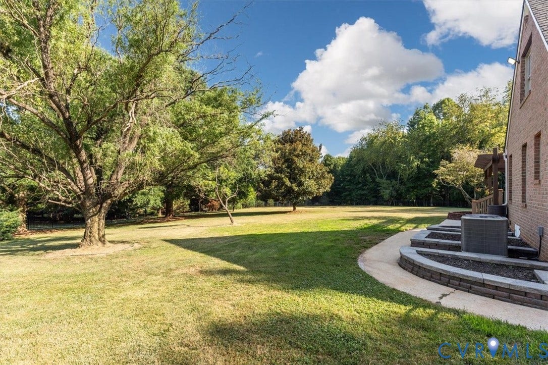 1437 Palmore Road, Powhatan, VA 23139 Expansive lawn area with mature trees and a curved concrete pathway