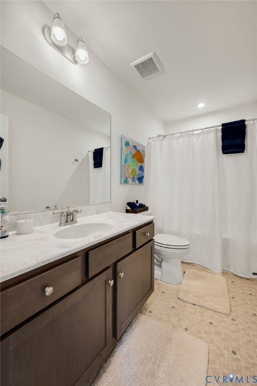 9217 Cerulean Place, Goochland, VA 23238 Bathroom featuring a vanity with a white stone-finish countertop, undermount sink, and dark wood-finish cabinetry