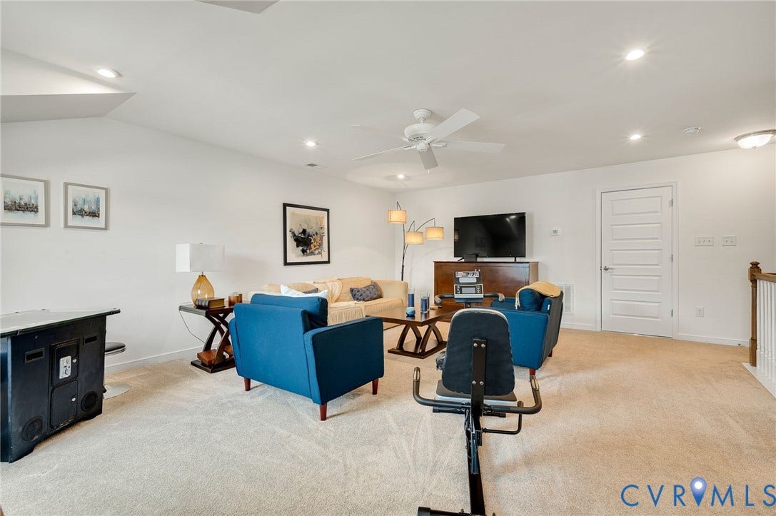 9217 Cerulean Place, Goochland, VA 23238 Spacious room featuring vaulted ceilings, recessed lighting, neutral carpeting, a ceiling fan, and a paneled door