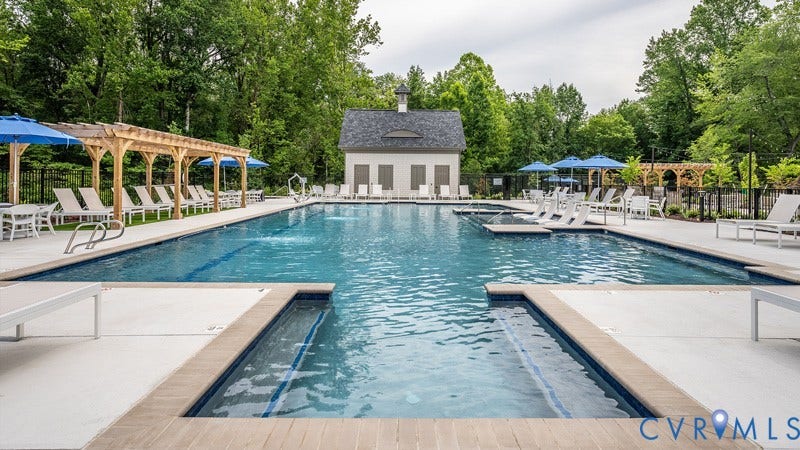 9217 Cerulean Place, Goochland, VA 23238 Expansive multi-pool aquatic area featuring a central building with cupola, surrounding concrete deck, wood-finish pool coping, and multiple pergolas providing shaded seating