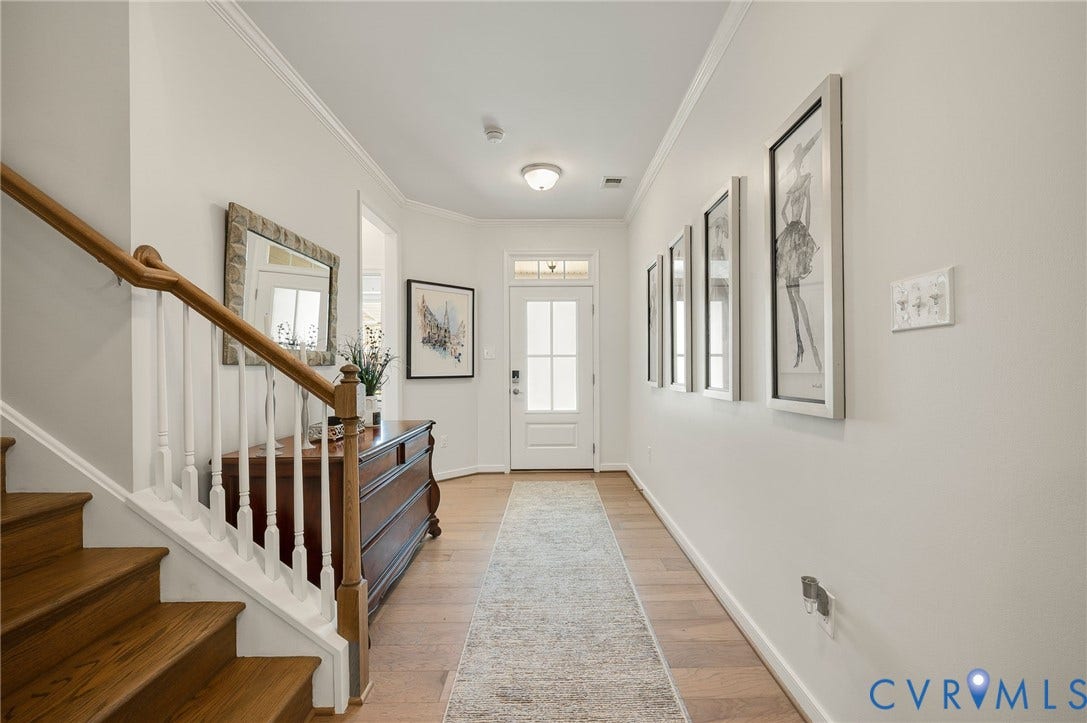 9217 Cerulean Place, Goochland, VA 23238 Entryway featuring warm wood-finish flooring, a staircase with white balusters and wood handrail, and a white paneled front door with decorative glass