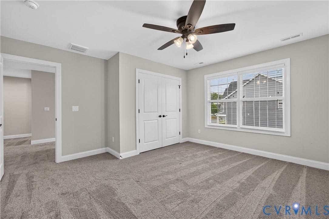 7238 Shenfield Avenue, Minutes To Short Pump, Glen Allen, VA 23059 Light gray interior walls with white trim, gray carpet flooring, a ceiling fan with integrated lighting, and a double-door closet with black hardware