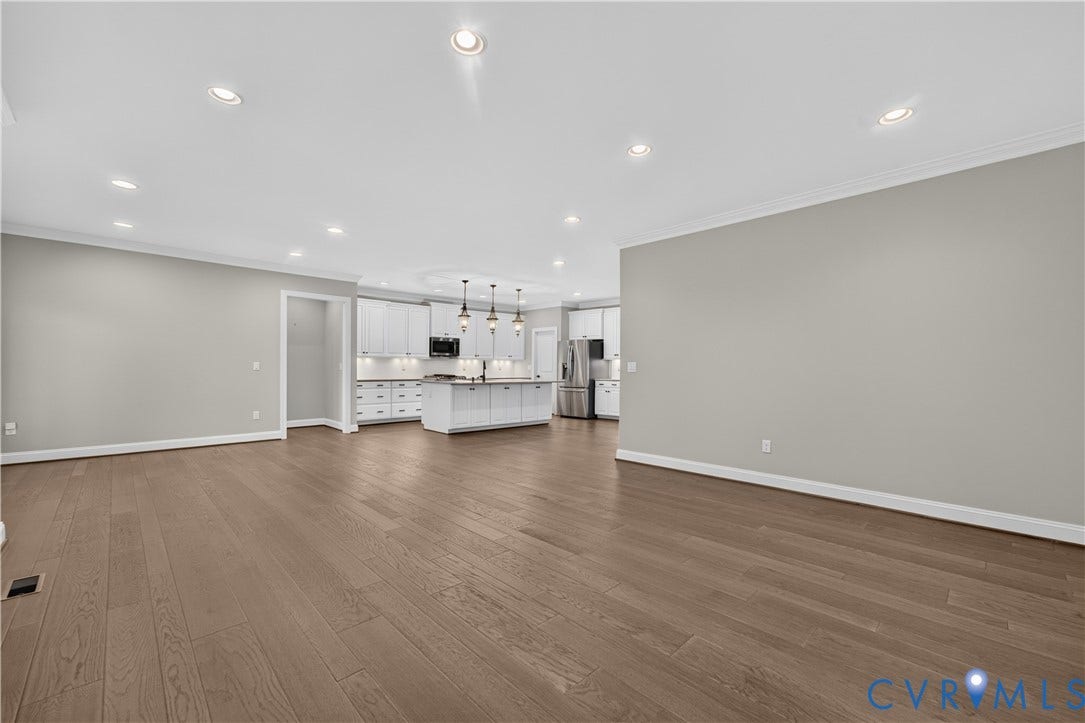 7238 Shenfield Avenue, Minutes To Short Pump, Glen Allen, VA 23059 Open-concept living space with wide plank wood-finish flooring, recessed lighting, crown molding, and a kitchen featuring white cabinetry, a large island, and stainless steel appliances