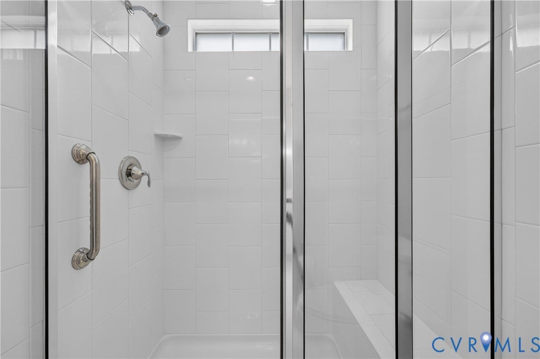 7238 Shenfield Avenue, Minutes To Short Pump, Glen Allen, VA 23059 Walk-in shower featuring white subway tile, a built-in bench, a grab bar, a shower head, and a transom window