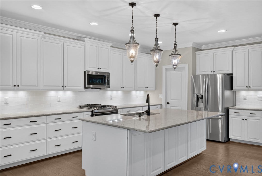 7238 Shenfield Avenue, Minutes To Short Pump, Glen Allen, VA 23059 Kitchen featuring white cabinetry, a central island with countertop, stainless steel appliances, a tile backsplash, and wood-finish flooring