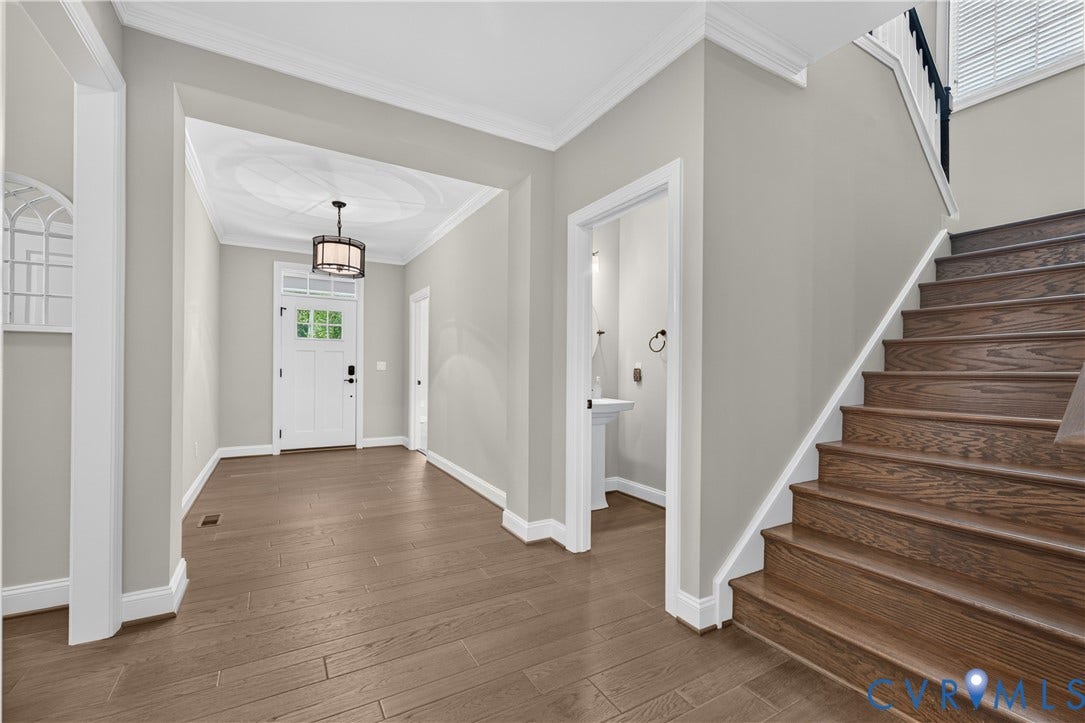 7238 Shenfield Avenue, Minutes To Short Pump, Glen Allen, VA 23059 Entry foyer featuring wood-finish flooring, a white paneled entry door with transom window, and a contemporary ceiling light fixture