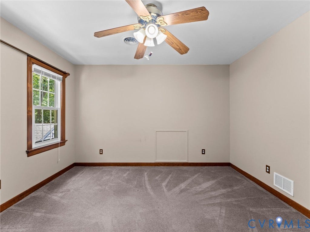 Room featuring neutral wall tones, wood-finish trim, and a ceiling fan with integrated lighting