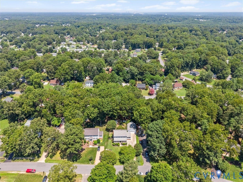 Aerial perspective showcasing a residential area characterized by mature tree coverage and numerous individual properties