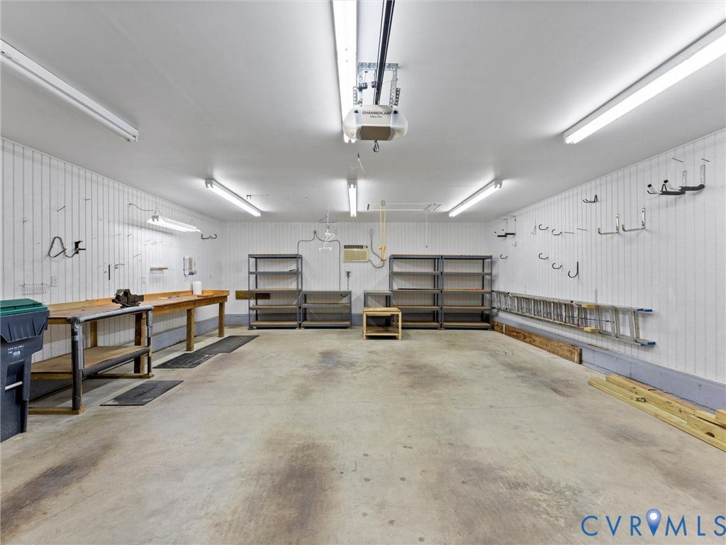 Spacious garage featuring concrete flooring and beadboard wall paneling