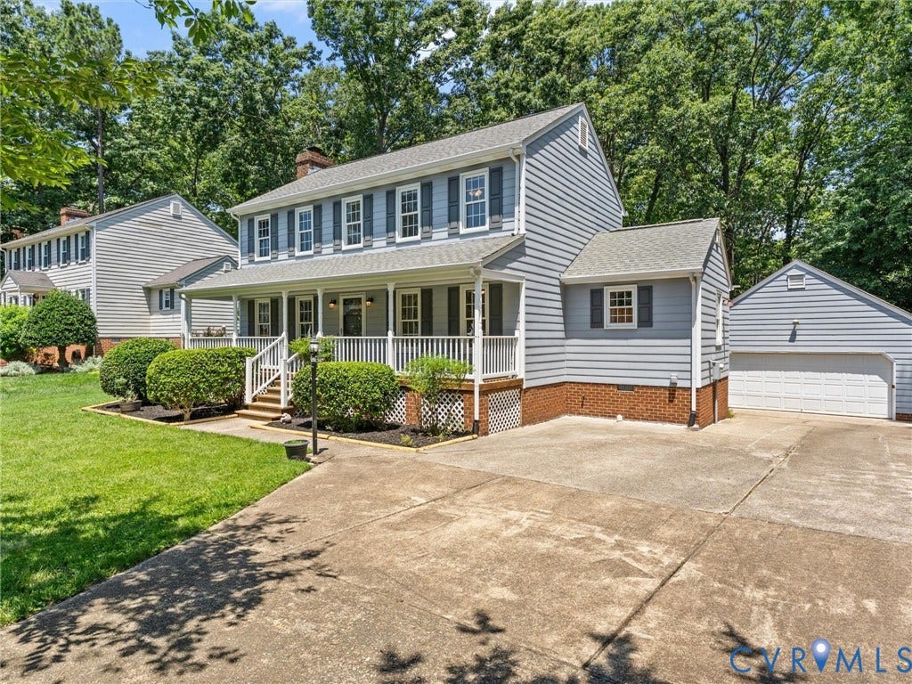 Traditional-style home featuring gray siding, white trim, and a full-width covered front porch