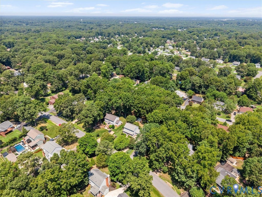 Aerial neighborhood perspective featuring extensive tree canopy and residential properties