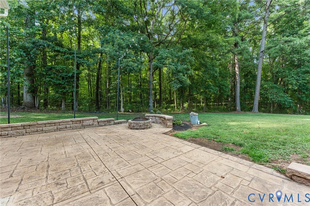 1496 Dorset Road, Powhatan, Powhatan, VA 23139 Expansive stamped concrete patio featuring a built-in stone fire pit and a stone retaining wall