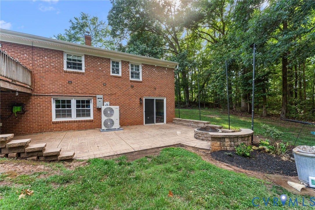 1496 Dorset Road, Powhatan, Powhatan, VA 23139 Expansive outdoor patio featuring stamped concrete, a built-in stone fire pit, and a stone retaining wall