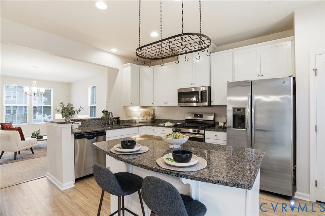 4101 New Hermitage Drive, Henrico, VA 23228 Open-concept kitchen featuring an island with seating, granite countertops, stainless steel appliances, white cabinetry, and wood-finish flooring