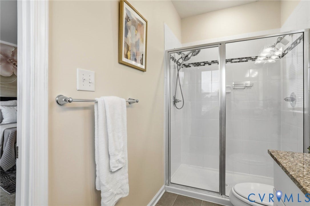 4101 New Hermitage Drive, Henrico, VA 23228 Walk-in shower with clear glass enclosure and tile surround featuring decorative accent band
