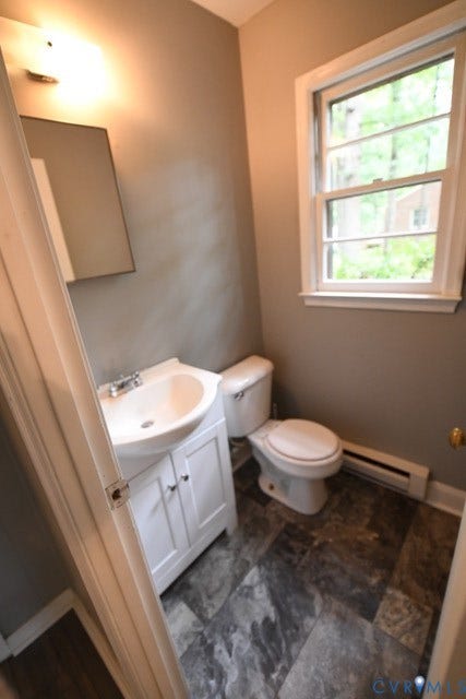 12720 Bailey Bridge Road, Bailey Bridge, Midlothian, VA 23112 Bathroom featuring a single-pane window, baseboard heater, modern vanity with a basin sink, and a wall-mounted mirror