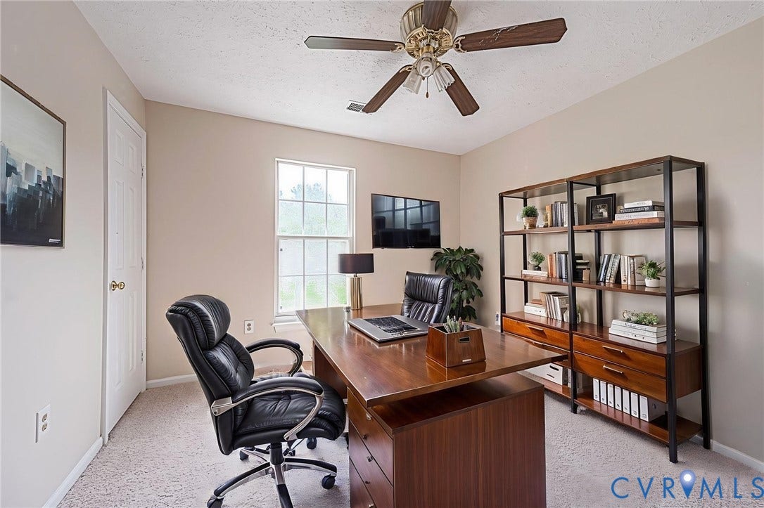 Carpeted room featuring a ceiling fan, a window, and light-colored wall paint~ Virtually Staged
