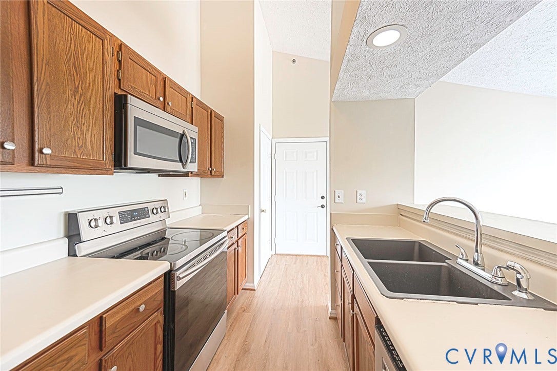 Kitchen featuring wood-finish cabinetry, stainless steel appliances, and light-colored countertops