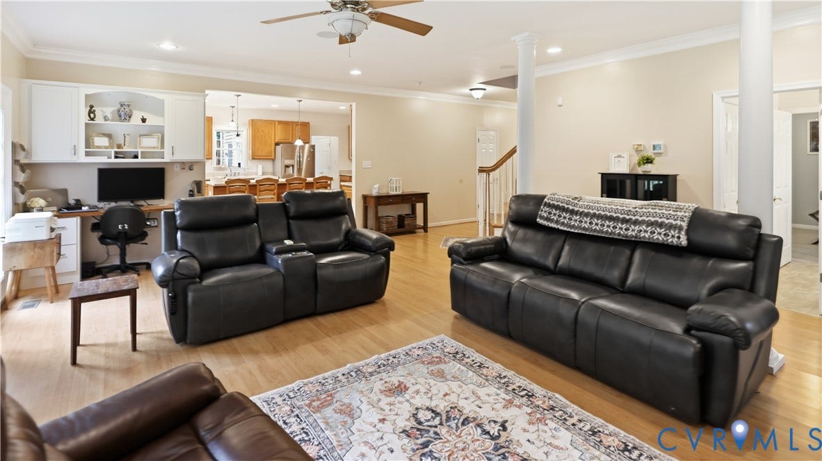 1836 Rocky Ford Road, Powhatan, VA 23139 Spacious living area featuring light wood-finish flooring, a ceiling fan with light fixture, recessed lighting, and a built-in desk area with upper cabinetry